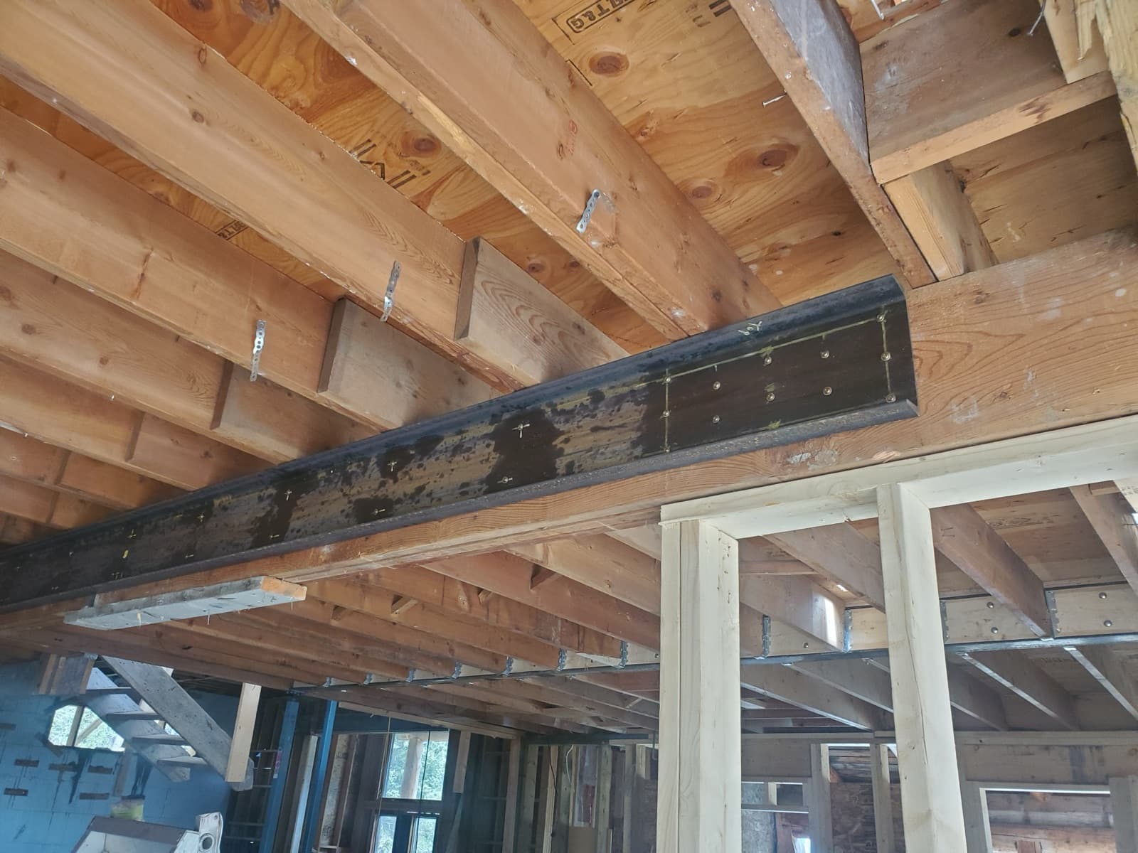 Black steel beam set into the floor joists