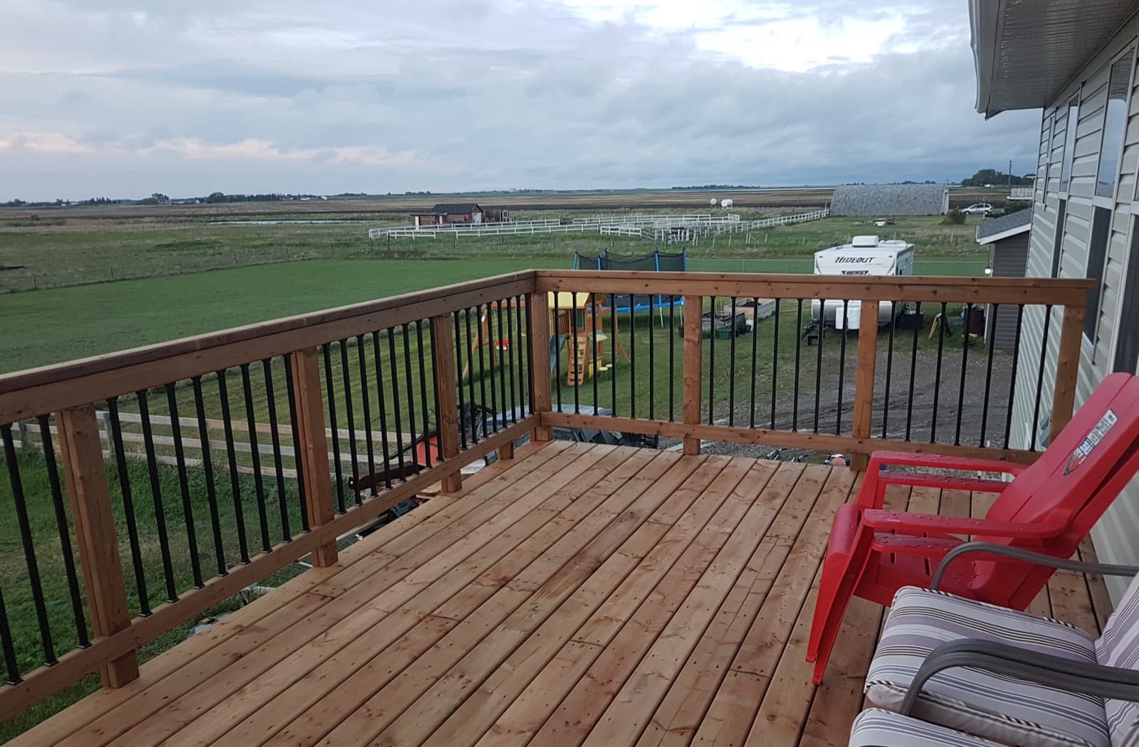 Cedar deck with a metal-spindle railing and Alberta view