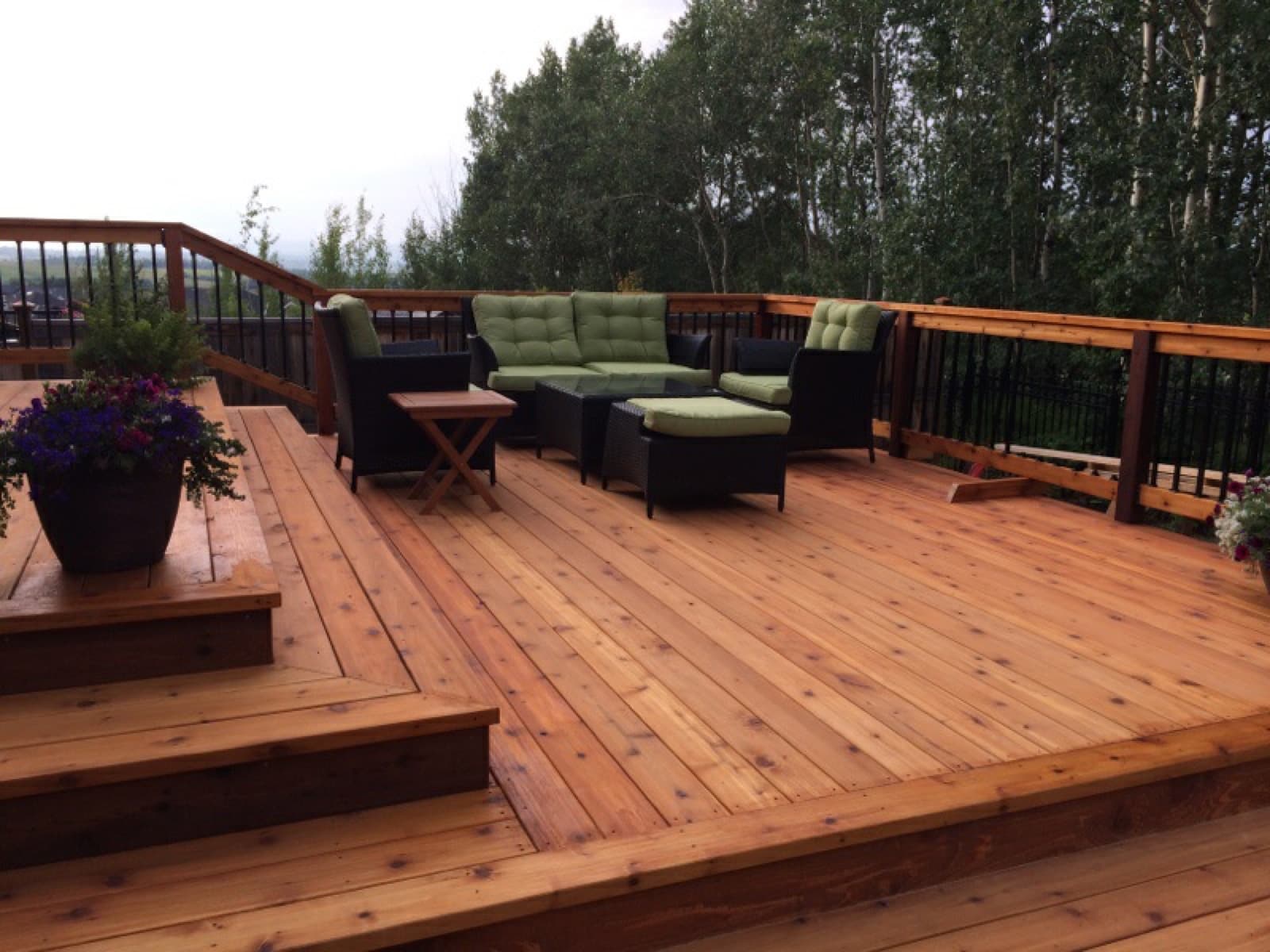 Finished deck with outdoor seating and a treeline view