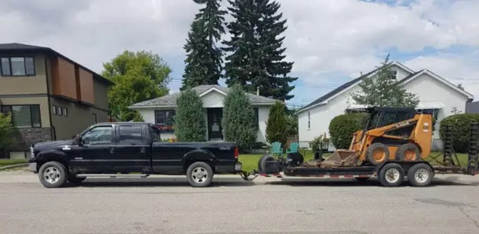 Skid steer loaded on a trailer at a job site