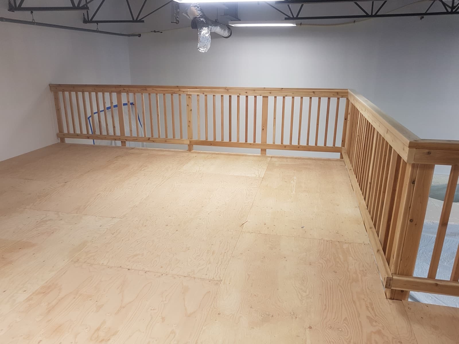 Framed interior mezzanine with a wood railing