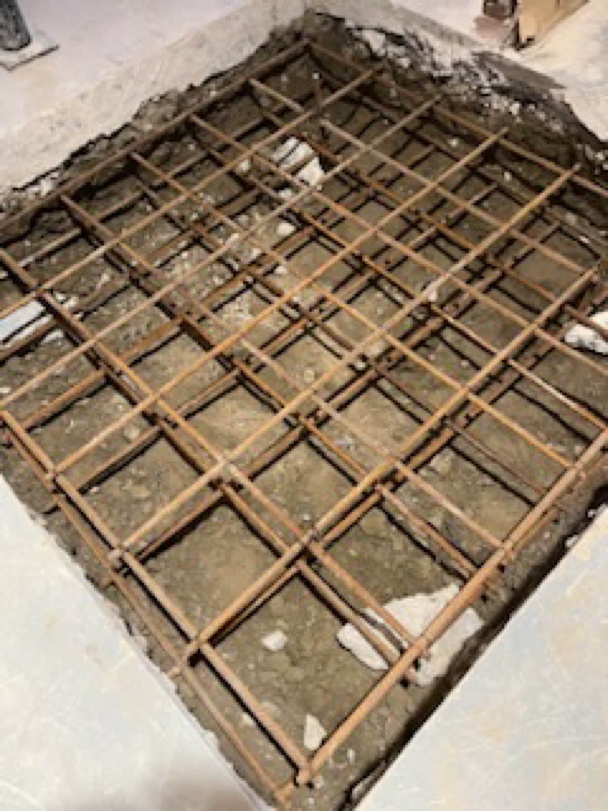 New concrete footing pad prepared for a structural post